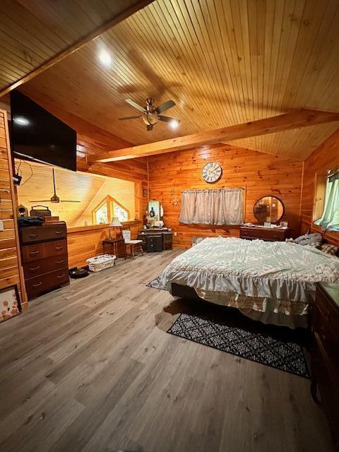 bedroom with wooden ceiling, beamed ceiling, wooden walls, and wood finished floors