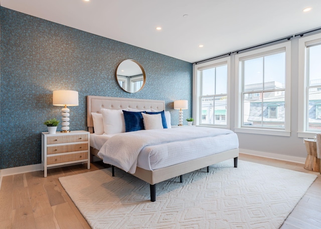 bedroom with recessed lighting, wallpapered walls, baseboards, and wood finished floors