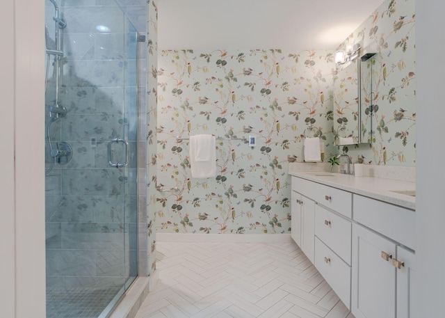 full bathroom featuring a sink, a stall shower, wallpapered walls, and double vanity