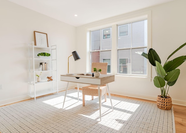 unfurnished office featuring recessed lighting, baseboards, and wood finished floors