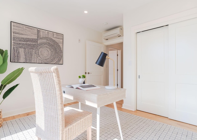 home office with recessed lighting, light wood finished floors, and a wall unit AC