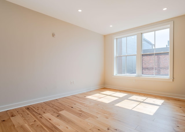 spare room with recessed lighting, baseboards, and light wood-type flooring