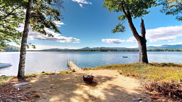 water view with a mountain view and a dock