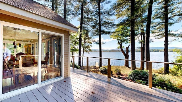 deck with a sunroom and a water and mountain view