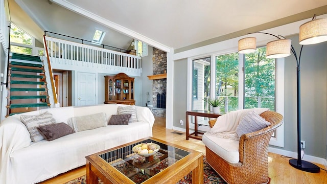 living room with hardwood / wood-style floors, plenty of natural light, a towering ceiling, and a fireplace