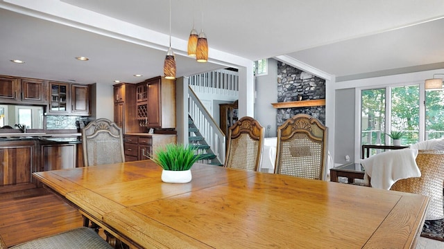 dining space featuring light hardwood / wood-style flooring and a stone fireplace