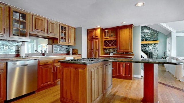 kitchen featuring a center island, sink, decorative backsplash, appliances with stainless steel finishes, and light hardwood / wood-style floors