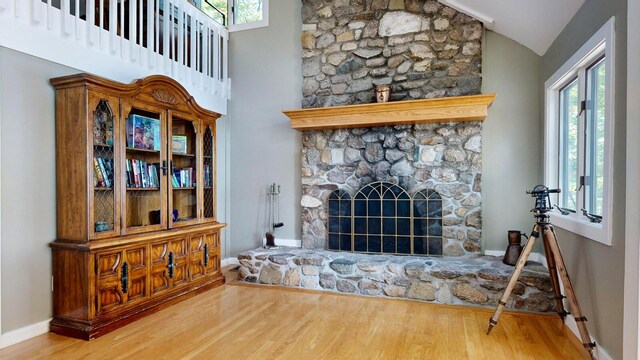 living room featuring a fireplace, a wealth of natural light, hardwood / wood-style floors, and lofted ceiling