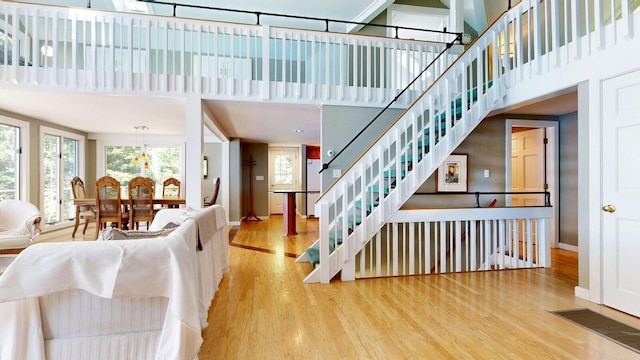 living room with a towering ceiling and hardwood / wood-style flooring