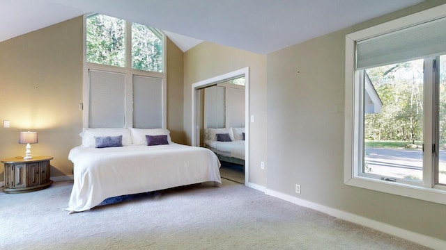 bedroom featuring carpet flooring, vaulted ceiling, and multiple windows