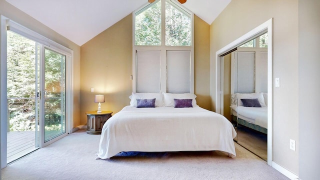 bedroom with multiple windows, light carpet, and access to exterior