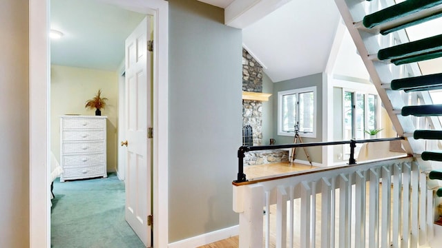 hallway featuring light carpet and vaulted ceiling