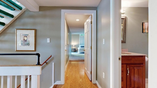 hall with light hardwood / wood-style flooring and sink