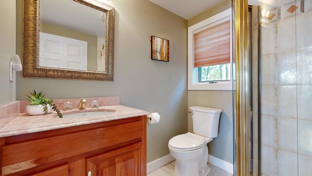 bathroom featuring tile patterned floors, vanity, toilet, and an enclosed shower