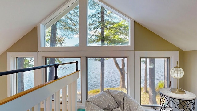 interior space with plenty of natural light, a water view, and high vaulted ceiling