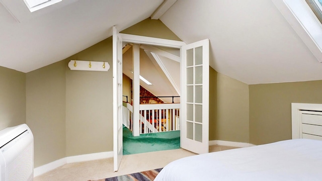 carpeted bedroom featuring heating unit and vaulted ceiling with skylight