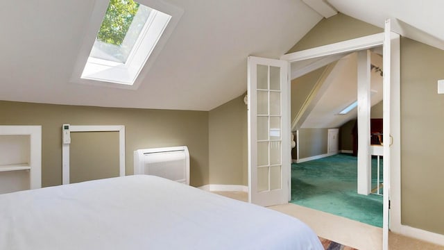 carpeted bedroom featuring vaulted ceiling with skylight