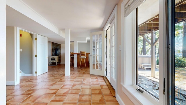 interior space with a healthy amount of sunlight, light tile patterned floors, and french doors