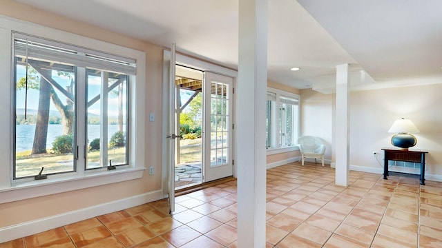 entryway featuring light tile patterned floors and a water view