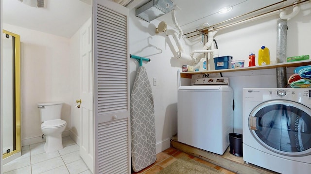 clothes washing area with separate washer and dryer and light tile patterned floors