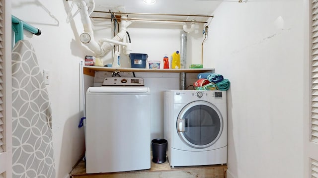 clothes washing area with washer and clothes dryer