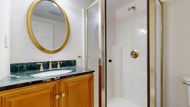 bathroom featuring vanity, toilet, and walk in shower