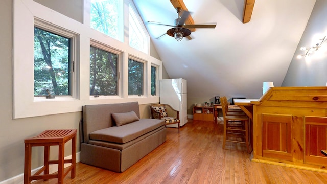 living area with light wood-type flooring, vaulted ceiling with beams, and plenty of natural light