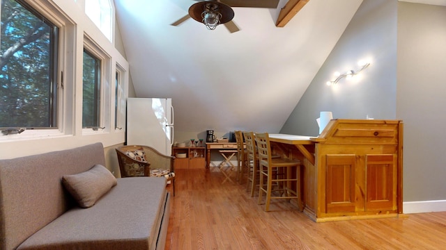 sitting room with a healthy amount of sunlight, light wood-type flooring, and lofted ceiling