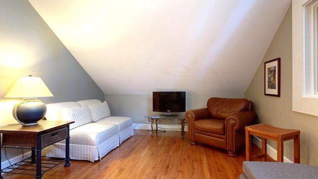 living area featuring vaulted ceiling and light hardwood / wood-style flooring