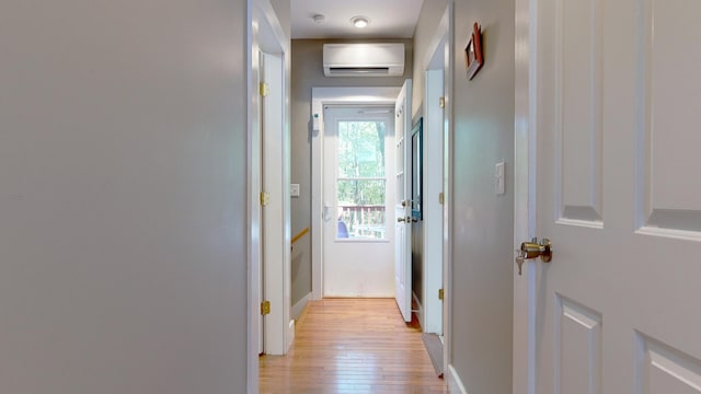 corridor with light hardwood / wood-style floors and a wall mounted air conditioner