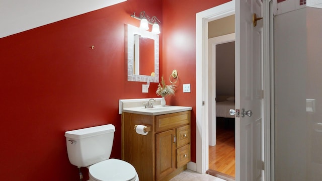 bathroom with wood-type flooring, vanity, and toilet