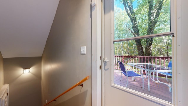 doorway with a wealth of natural light and lofted ceiling