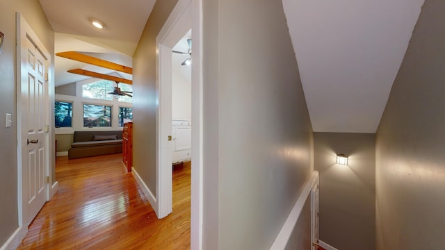 hallway with lofted ceiling with beams and light hardwood / wood-style flooring