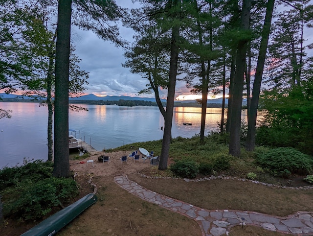 water view with a mountain view and a dock