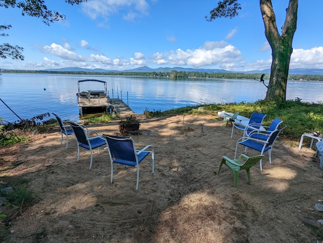 water view with a mountain view and a dock