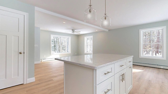 kitchen featuring white cabinetry, plenty of natural light, decorative light fixtures, and a center island