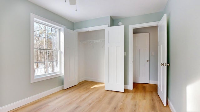 unfurnished bedroom with light hardwood / wood-style floors, ceiling fan, and a closet