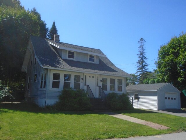 view of front of home featuring an outdoor structure, a garage, and a front lawn