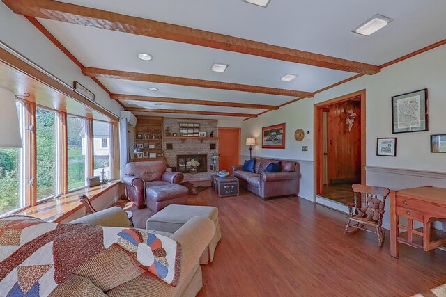 living room featuring hardwood / wood-style flooring, beamed ceiling, and a brick fireplace