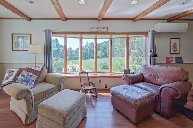 living room featuring a wall unit AC, hardwood / wood-style flooring, and beam ceiling