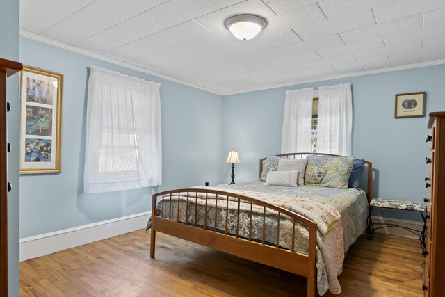 bedroom with light hardwood / wood-style floors and crown molding