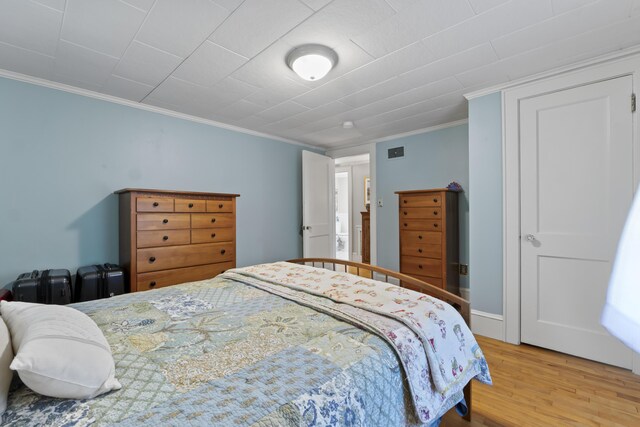 bedroom featuring crown molding and hardwood / wood-style flooring