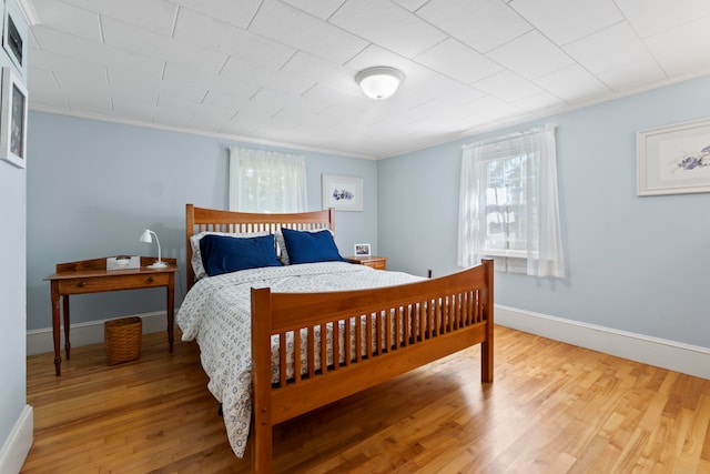 bedroom with crown molding and wood-type flooring