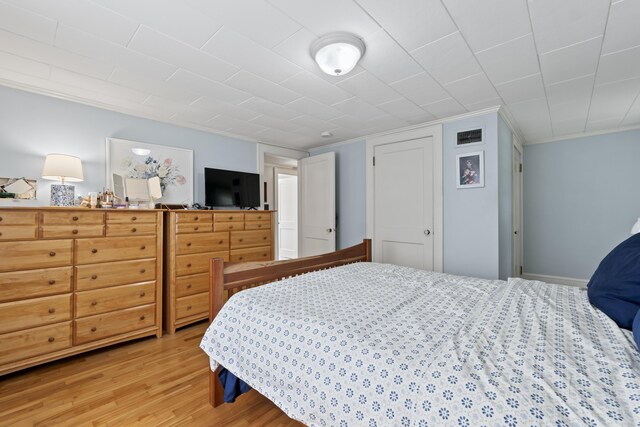 bedroom with wood-type flooring and ornamental molding