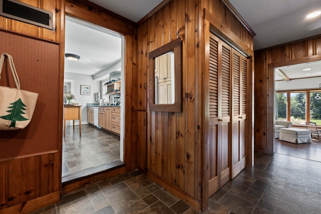 hallway featuring wood walls