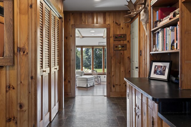 corridor featuring wood walls and ornamental molding