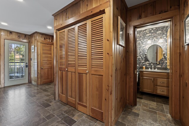 interior space featuring wooden walls, crown molding, and sink