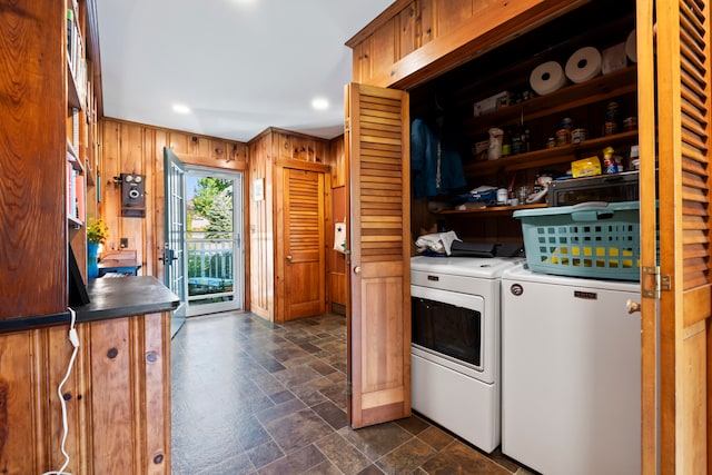 laundry area featuring wood walls and washer and dryer