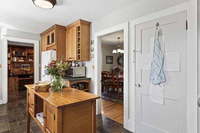 kitchen with dark wood-type flooring, white refrigerator, and a notable chandelier