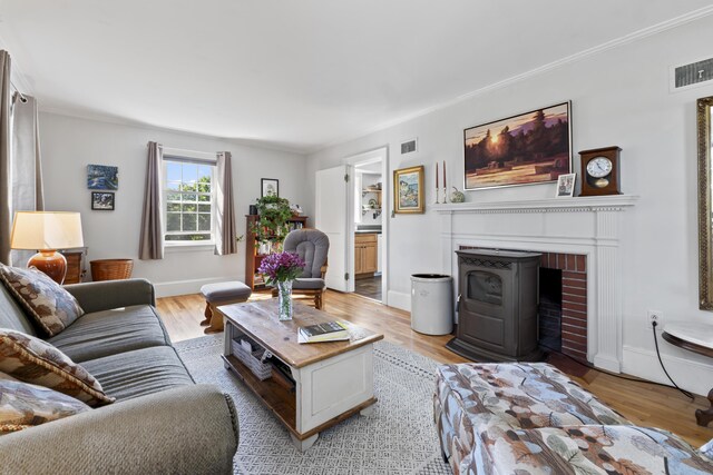 living room with a fireplace, ornamental molding, and hardwood / wood-style flooring